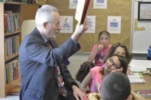 Mike's granddaughter Zoe beams with pride as he reads to her class